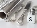 Silber reinigen: Alufolie, Salzstreuer und Besteck liegen bereit für die Hausmittel-Reinigung.