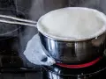 Milch kocht über und läuft auf den Herd. Das bedeutet, der Herd muss gereinigt werden.