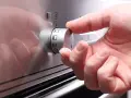 Hand dreht Regler mit Backofen Symbolen.