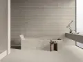 Modernes Bad mit Wanne und Waschtisch. Die geriffelten Wandfliesen und Terrazzo-Bodenfliesen sind leicht zu reinigen.