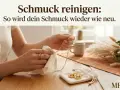 Hände polieren eine goldene Halskette und Ringe mit einem Tuch. So wird Modeschmuck reinigen zum Kinderspiel.