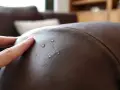 Wassertropfen perlen auf braunem Leder ab. So einfach ist nubukleder reinigen und schützen.