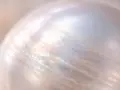 Nahaufnahme einer schimmernden Perle, die auf Glanz und Pflege für eine Perlenkette hinweist.