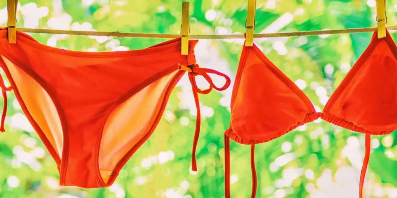 Roter Bikini trocknet an der Wäscheleine. Nach dem **Bikini waschen** duftet er frisch in der Sonne.