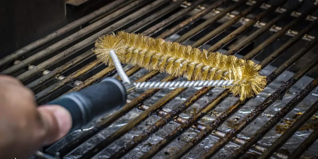 Mit einer Messingbürste werden emaillierte Grillroste von hartnäckigen Verschmutzungen befreit.