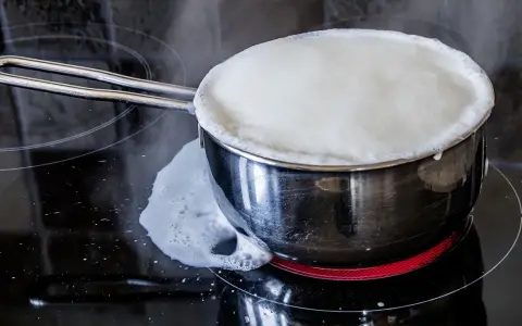 Milch kocht über und läuft auf den Herd. Das bedeutet, der Herd muss gereinigt werden.
