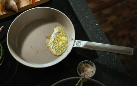 Butter schmilzt in einer beschichteten Pfanne, bereit für das Braten von Fisch.