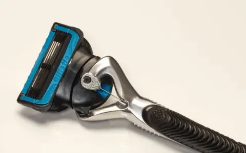 Ein Rasierer mit blauer Kappe und mehreren Klingen. Die Rasierklingen reinigen sanft die Haut für eine glatte Rasur.