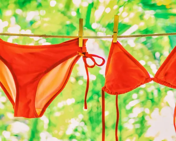 Roter Bikini trocknet an der Wäscheleine. Nach dem **Bikini waschen** duftet er frisch in der Sonne.