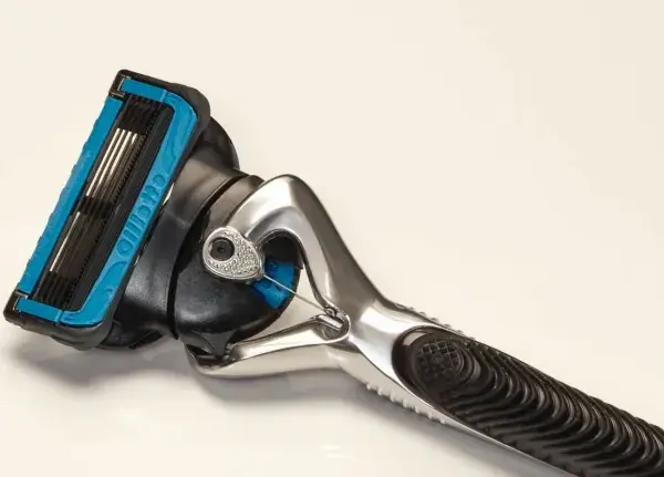 Ein Rasierer mit blauer Kappe und mehreren Klingen. Die Rasierklingen reinigen sanft die Haut für eine glatte Rasur.
