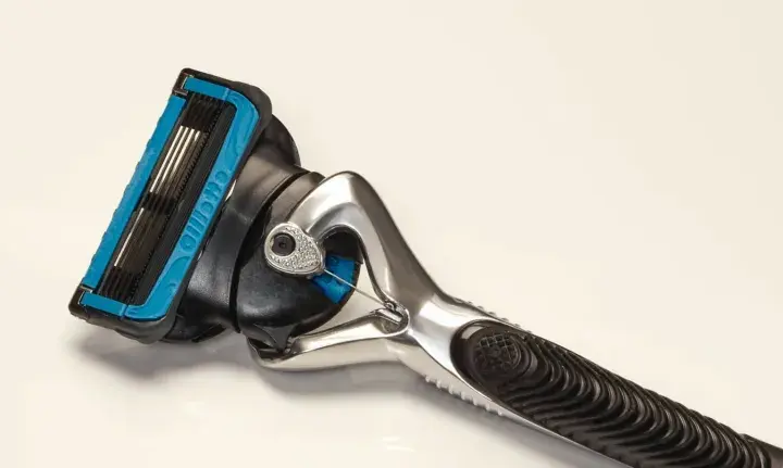 Ein Rasierer mit blauer Kappe und mehreren Klingen. Die Rasierklingen reinigen sanft die Haut für eine glatte Rasur.