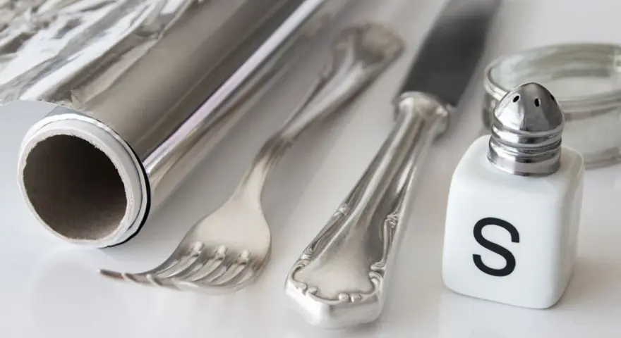 Silber reinigen: Alufolie, Salzstreuer und Besteck liegen bereit für die Hausmittel-Reinigung.