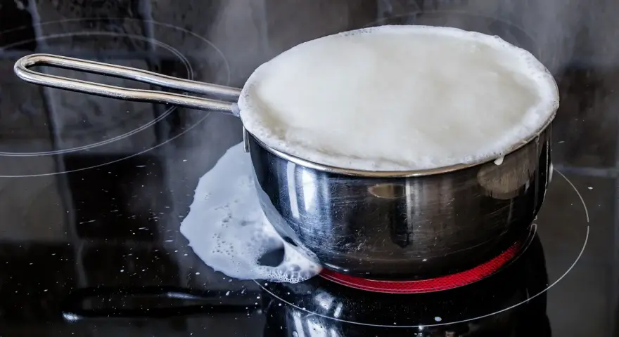 Milch kocht über und läuft auf den Herd. Das bedeutet, der Herd muss gereinigt werden.