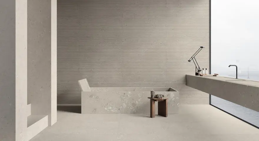 Modernes Bad mit Wanne und Waschtisch. Die geriffelten Wandfliesen und Terrazzo-Bodenfliesen sind leicht zu reinigen.