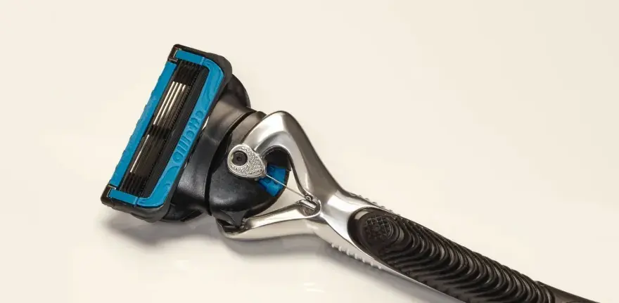 Ein Rasierer mit blauer Kappe und mehreren Klingen. Die Rasierklingen reinigen sanft die Haut für eine glatte Rasur.