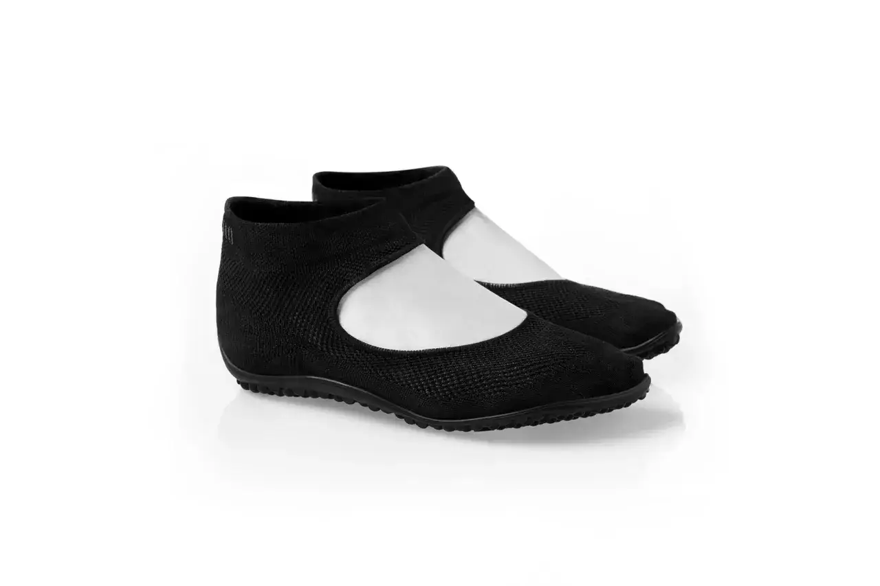 Schwarze, gestrickte leguano schuhe mit weißem Einsatz, bereit zum Waschen.